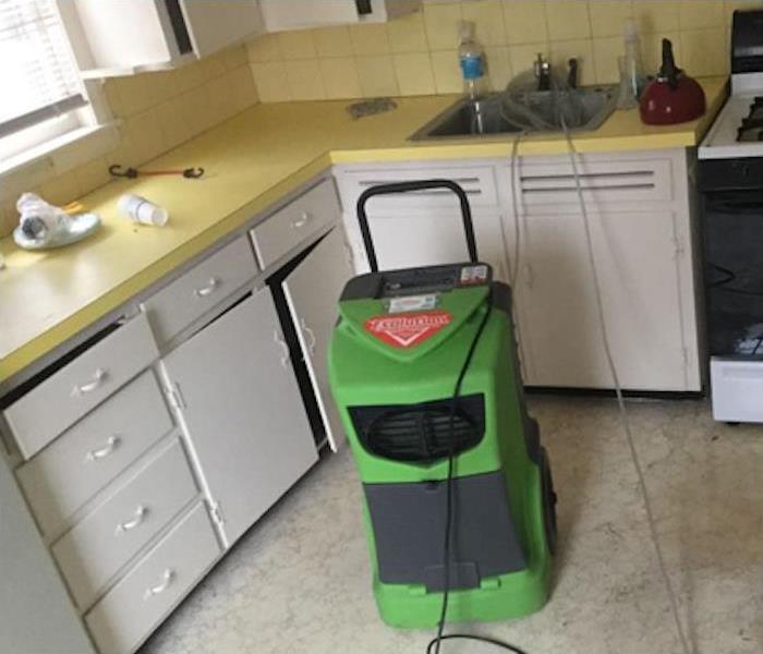 kitchen with water damage and SERVPRO equipment setup