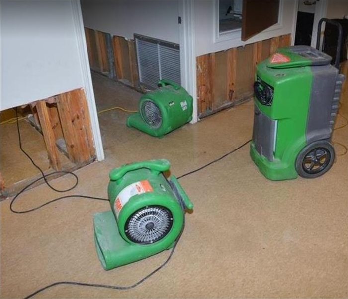 SERVPRO water damage equipment being used in hallway. Flood cuts on wall