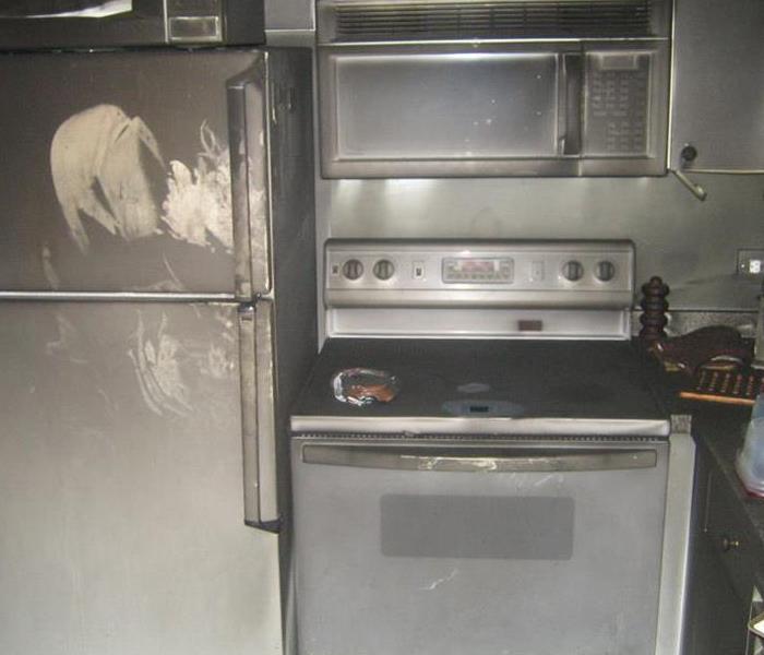 A kitchen covered in soot after a fire