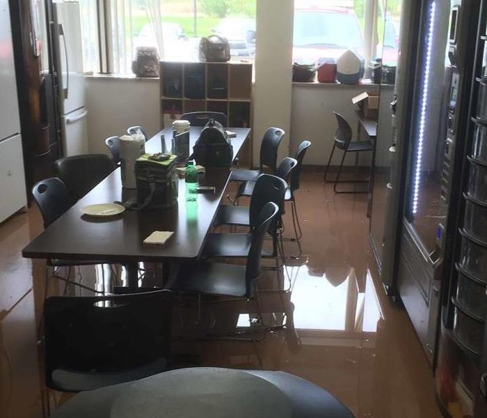 an office kitchen with water on the floor